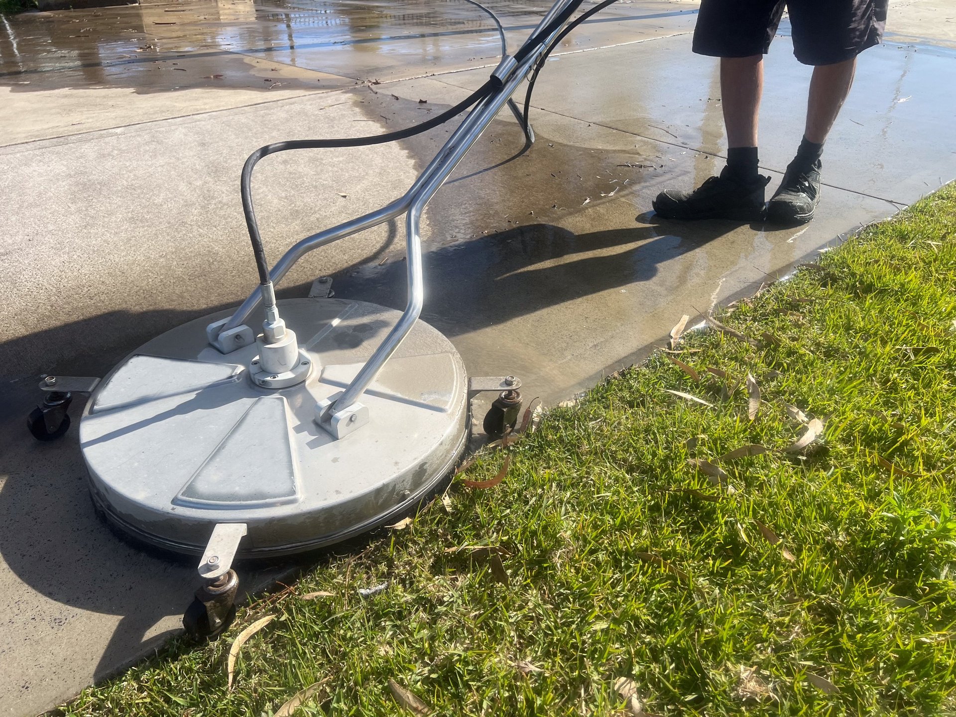 Worker using surface pressure washer to remove paint, mold and grime